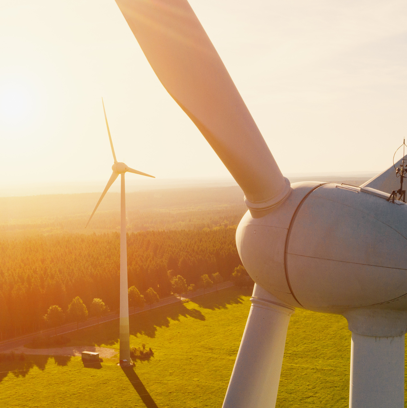 Energy Windradausschnitt im Vordergrund- im Hintergrund ein komplettes Windrad in der Landschaft