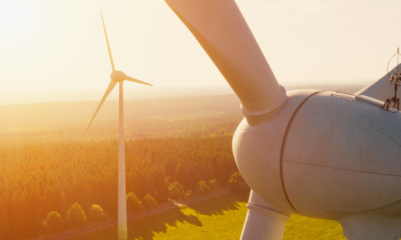 Windradausschnitt im Vordergrund- im Hintergrund ein komplettes Windrad in der Landschaft